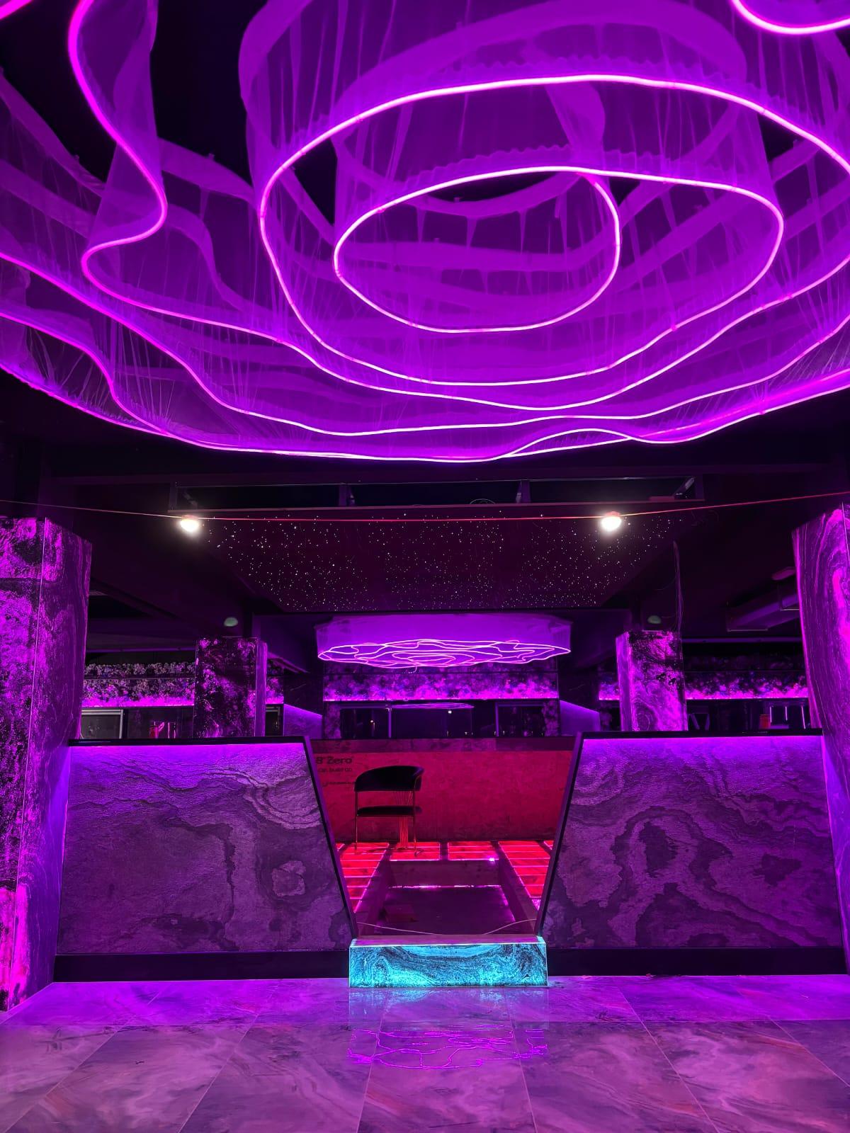 Photograph — sculpted purple feature ceiling above the illuminated counter, Café interior fit-out, Birmingham