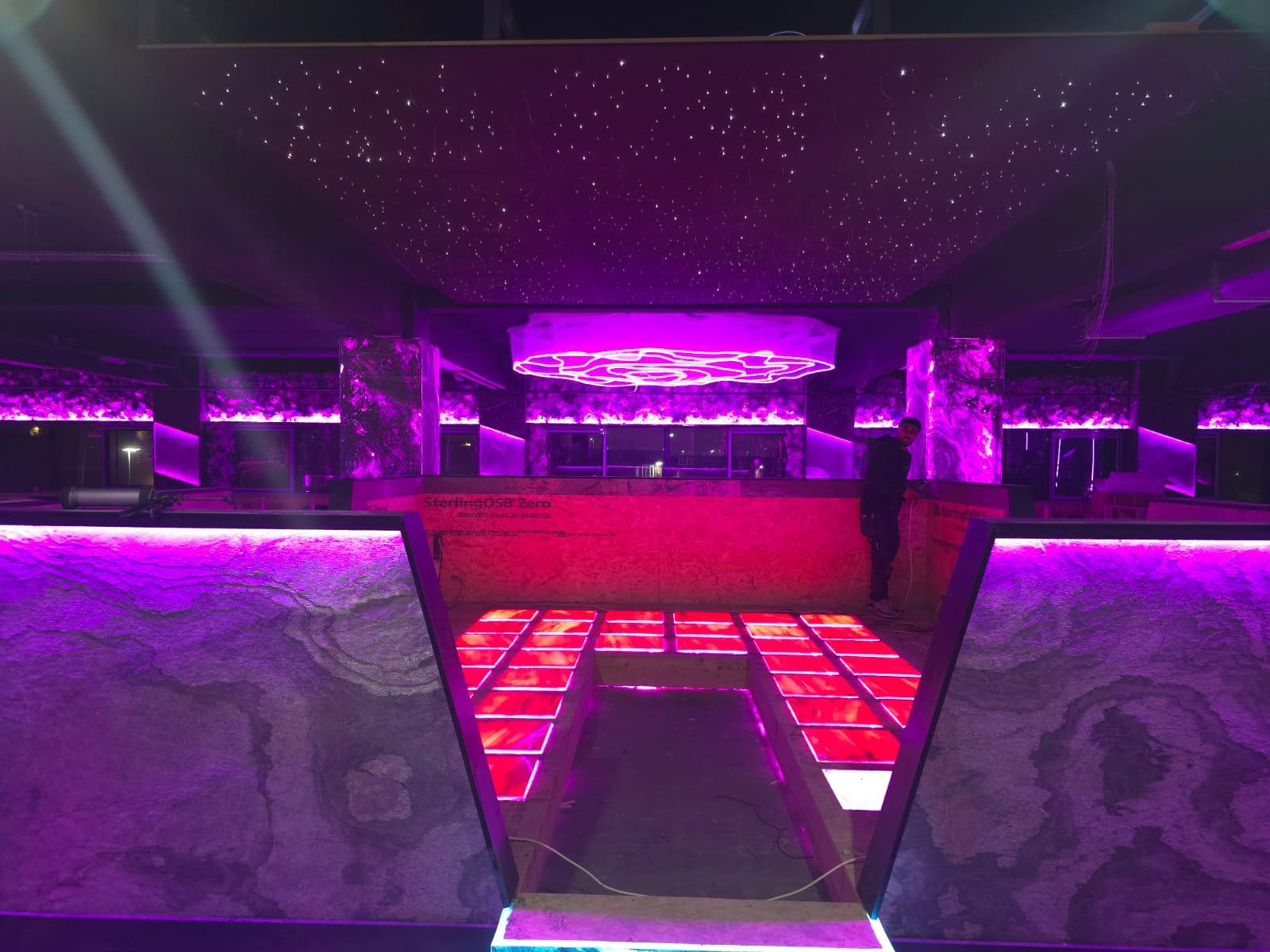 Photograph — front counter with illuminated stone panels and starlit ceiling, Café interior fit-out, Birmingham